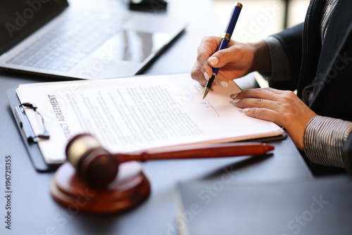 Canvastavla Female lawyer reviewing and signing a legal document while working on a case in her office