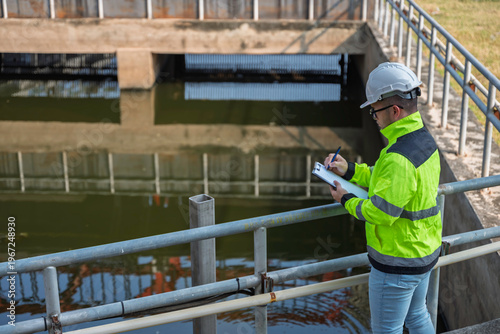 Fotografie Professional Asian engineer inspecting water quality at a wastewater treatment plant