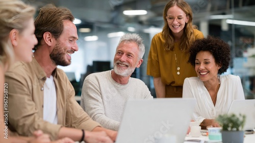 Teamwork and Laughter in the Office: colleagues in a bright office space. The image captures a moment of connection, and productivity.