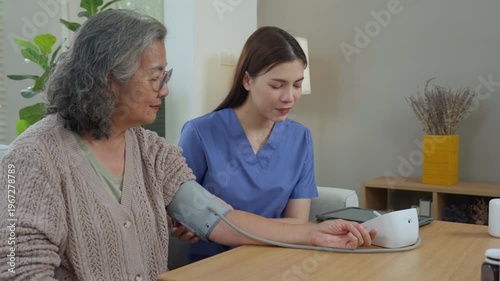 Caregiver elderly care home nurse blood pressure monitor health support living room gentle cuff check, routine checkup for wellness and safety, calm monitoring as nurse measures elderly woman arm