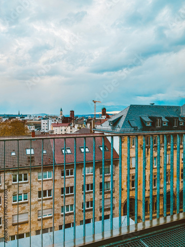 Moody European Cityscape with Historic Rooftops, Church Towers  under Dramatic Cloudy Sky