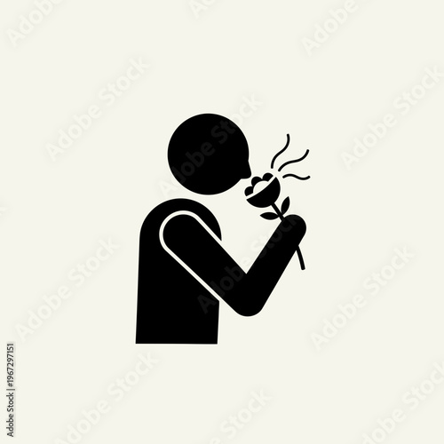 Person smelling a flower enjoying the pleasant aroma and fragrance.