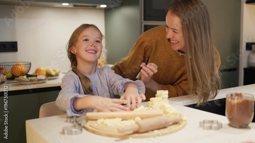 Mother and daughter baking cookies together in the kitchen, sharing a happy family moment