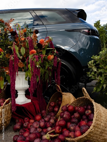 Luxury car with autumn floral arrangement and apples in stylish outdoor setup