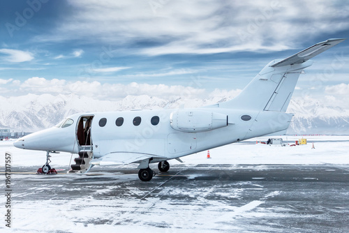 Quadro su tela Modern white bizjet with an opened gangway door at the winter airport on the bac