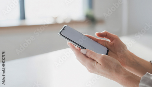 Female Hands Holding Modern Smartphone in Bright Minimalist Setting
