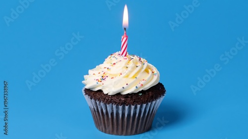 Chocolate Cupcake With Cream Frosting and a Candle on a Blue Background Durin...