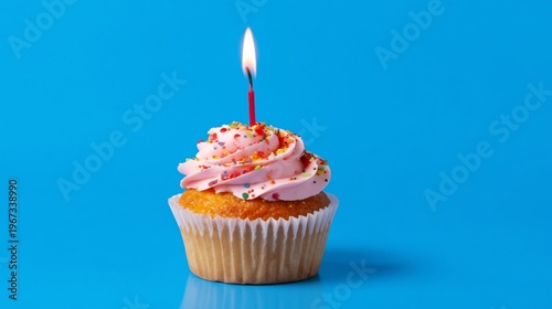 Chocolate Cupcake With Cream Frosting and a Candle on a Blue Background Durin...