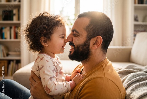 Loving Middle Eastern Father and Toddler Daughter Sharing Tender Nose Touch Moment at Home in Warm Morning Light