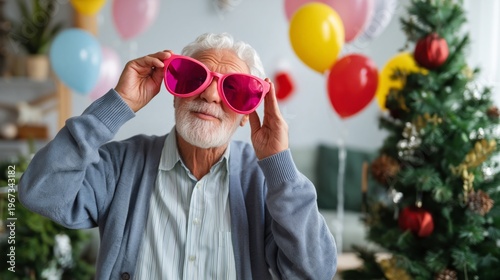 Man Looks up at Christmas Tree With Lights and Decorations in Cozy Room Durin...