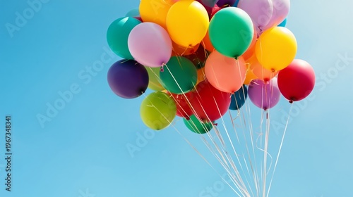 Colorful Balloons Float in the Sky of a Clear Day With Bright Sun and No Clou...