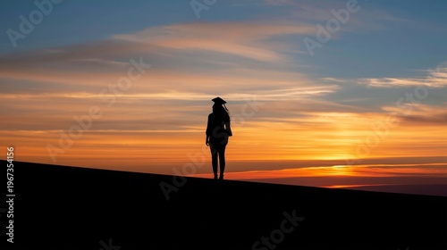 Graduation Ceremony at Sunset With a Graduate in Cap and Gown Standing on the...