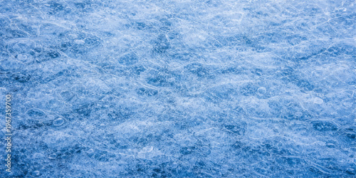 Abstract winter background of blue wool and frozen ice texture with white snow patterns and crystal frost under a cold cloudscape sky