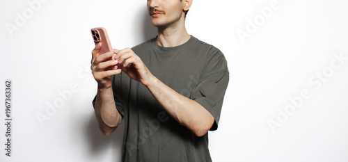 Young man making video and photo content on smartphone isolated on white background.
