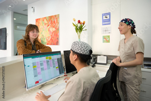 Patients checking in at busy medical clinic reception