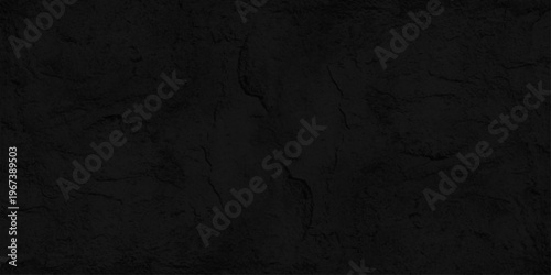 Black concrete wall texture background with subtle cracks and stone grain, dark cement plaster surface for backdrop