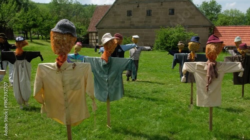 Many brightly dressed scarecrows in a meadow