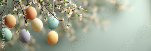 Easter banner with colorful hanging eggs on blossoming spring branches and copy space for text