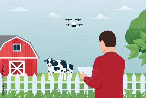A man operates a drone over a farm with a red barn and cow