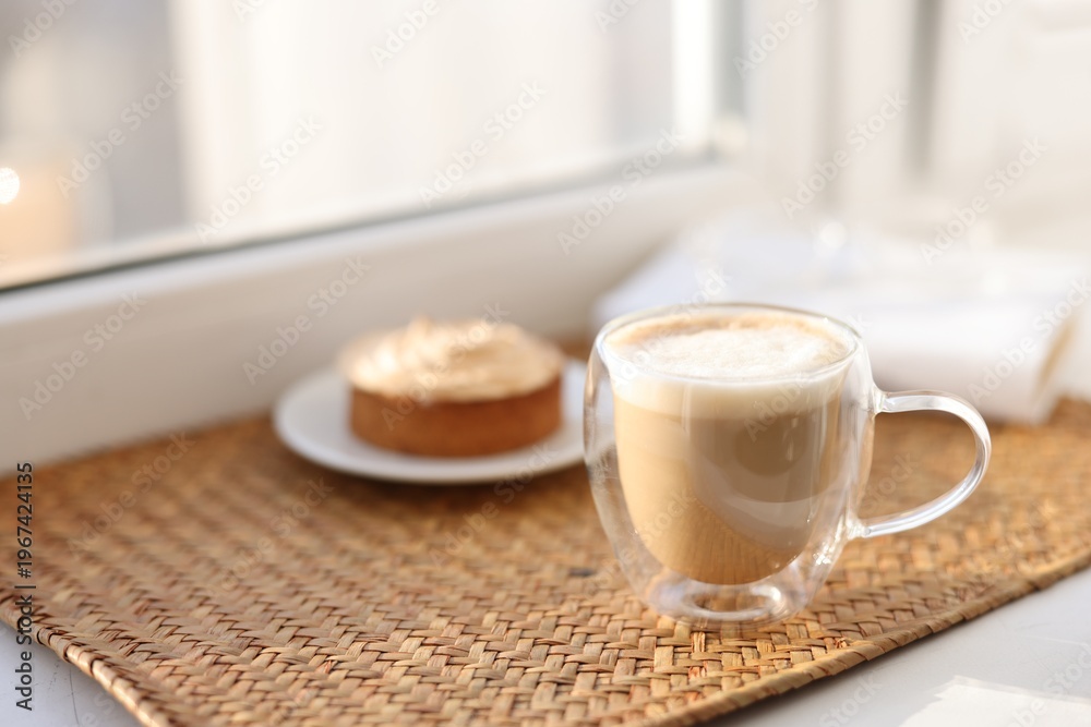 Obraz premium Aromatic coffee in glass cup and delicious tart on windowsill, closeup. Space for text