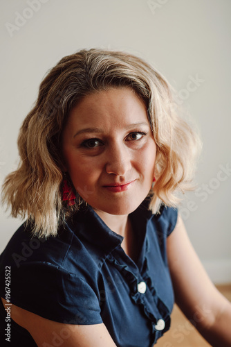 Woman portrait looking at camera with natural expression indoors