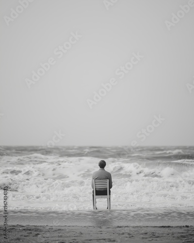 Lonely person sitting on a chair facing the ocean, reflecting on life, calmness and inner balance.
