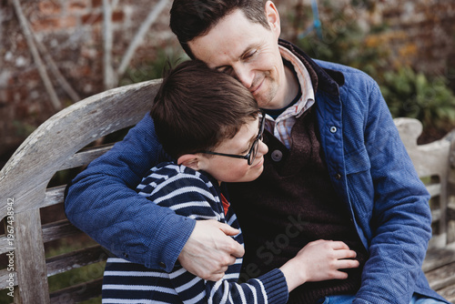 Father hugging son close outdoors showing affection and care