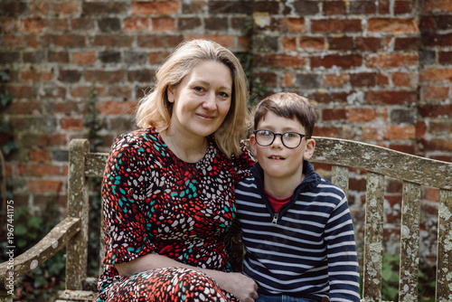 Mother and son portrait sitting together outdoors in front of brick wall