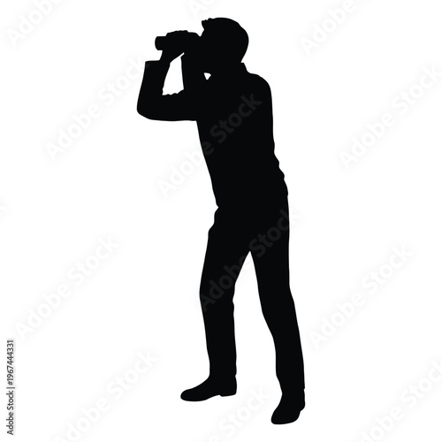 A lone figure observes the distance with binoculars a striking black silhouette
