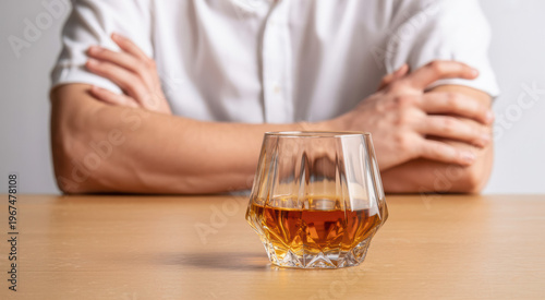 Whiskey Glass on Wooden Table with Man in Background