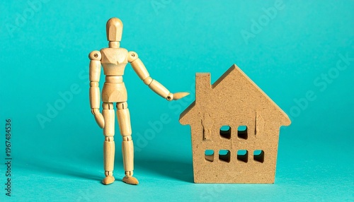 Wooden Mannequin Standing Next to Toy House