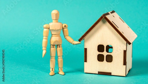 Wooden Mannequin Standing Next to Toy House