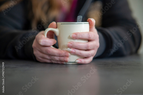 Bild auf Leinwand mains d'une femme autour d'un mug blanc