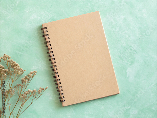 Kraft Spiral Notebook with Dried Wildflowers Flat Lay on Mint Green Background