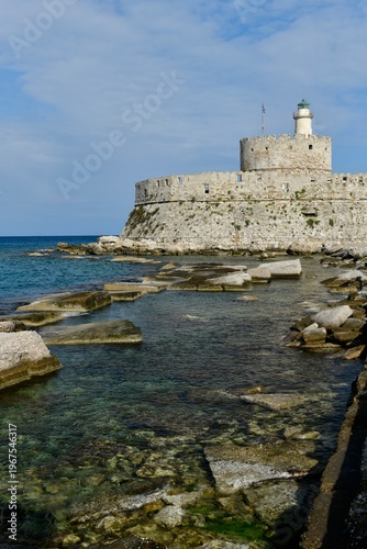 Saint Nicolas Fortress, Mandraki harbor, Rhodes Island, Greece. Stone structure at the harbor entrance and Colossus of Rhodes area.