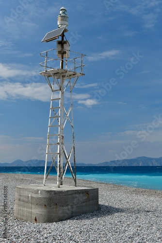 Elli beach ,Rhodes Island, Greece. A small beacon on the most Northerly peninsula of the island, and the distant Turkey's coastline.