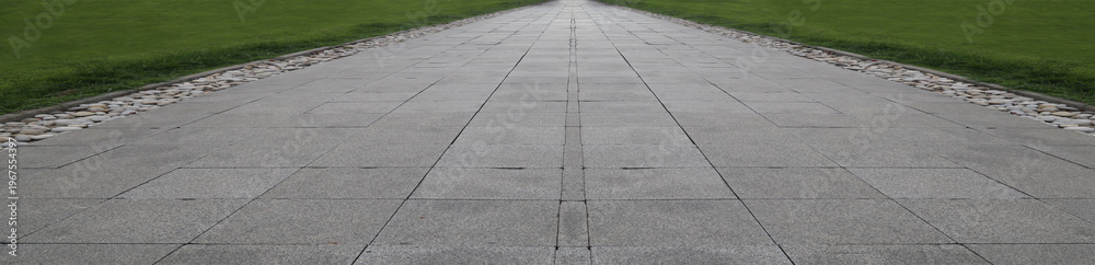 Obraz premium tile tiled walkway floor flooring with green bush on the side Decorative shrubs and green ornamental plant beside with stone pavement floor, perspective side view with empty copy space Batumi Georgia