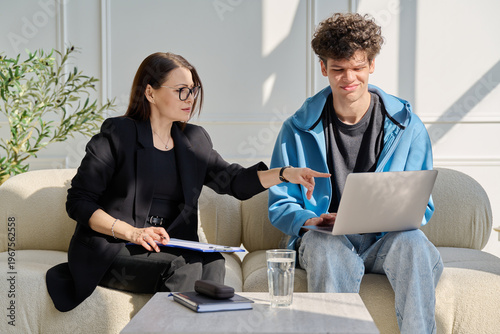 Psychological session therapy, young guy and therapist looking at computer together