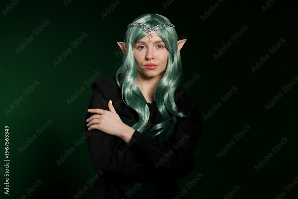 Obraz premium Beautiful girl dressed as elf on dark green background