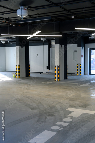 Modern empty parking garage interior with marked spaces and lighting