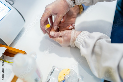 Canvas Print Pharmacist performing a blood test finger prick