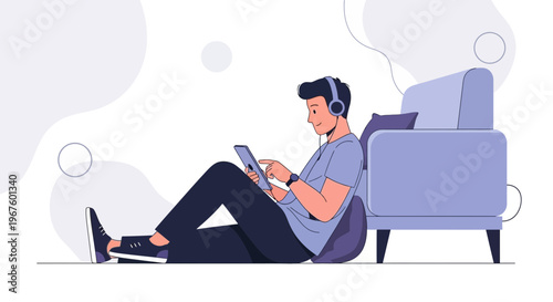 Man with headphones using tablet while sitting on floor near sofa