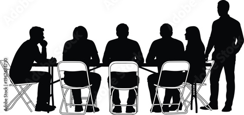 Silhouette of a group of people sitting at a long table for a business meeting conference seminar or community discussion