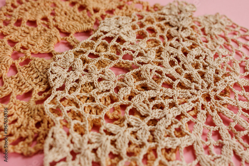 Fotografía Layered beige crochet lace doilies on pink background close up with overlapping