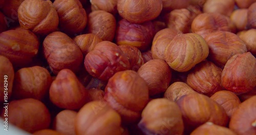 Peeled hazelnut kernels lie on a plate. Close-up