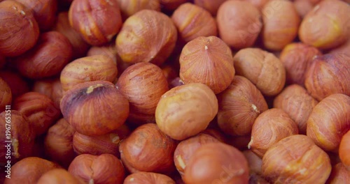 Peeled hazelnut kernels lie on a plate. Close-up