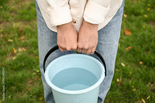 Woman with plastic bucket o...