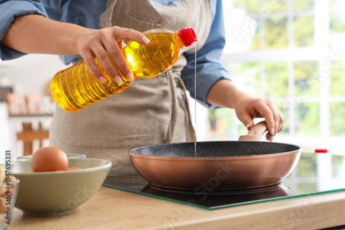 Young woman pouring sunflow...