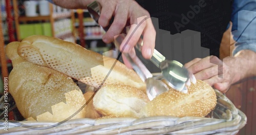 Picking up sesame roll with metal tongs at bakery, vendor wearing blue shirt handling wicker basket