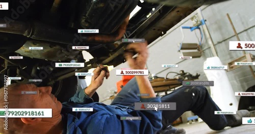 Mechanic reaching, aligning wrench under car, turning bolt for repair while AR tags tracking parts